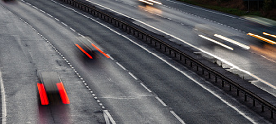 Cars speed by on a motorway.